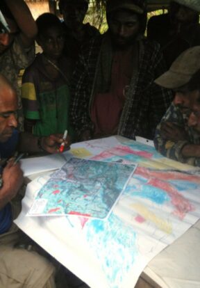 Mapping Officer transferring sketch maps onto a master copy in Papua New Guinea