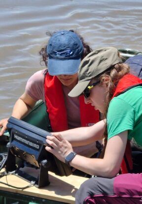 Two women on boat conducting conservation research